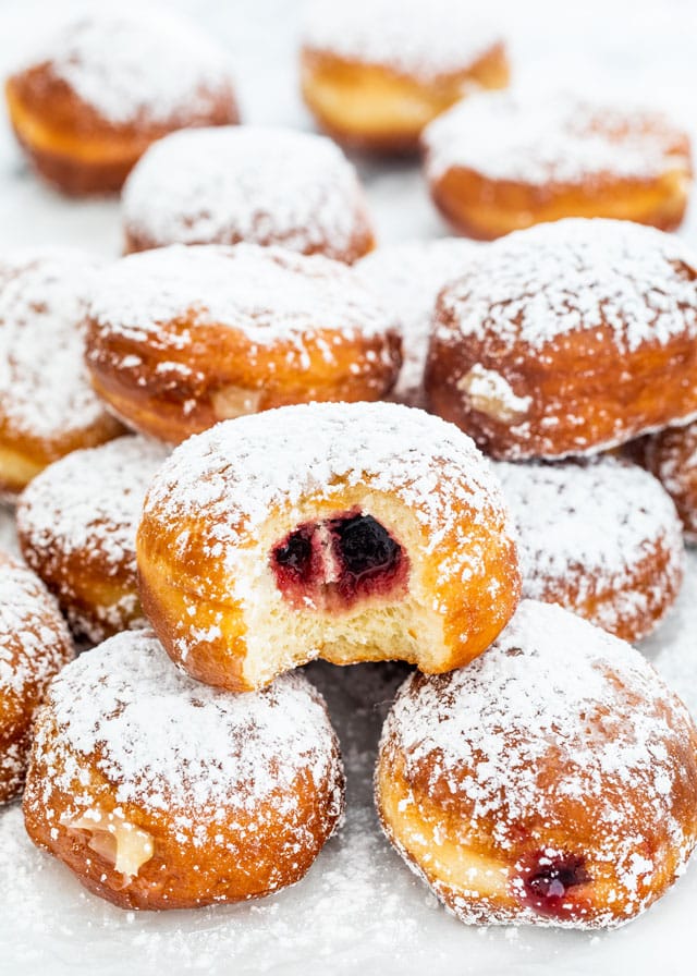 a bunch of Paczki on parchment paper