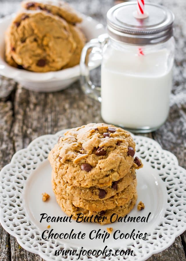 Peanut Butter Oatmeal Chocolate Chip Cookies stacked on a plate with a glass of milk in the background