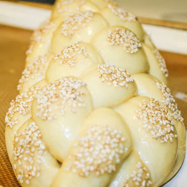 Sesame seeds are added to the top of the braided dough