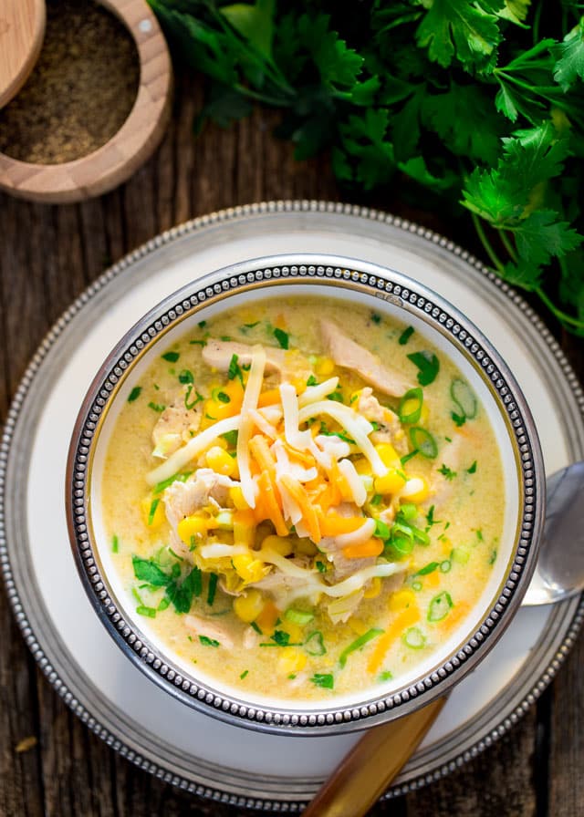 overhead of a bowl of Chicken and Corn Chowder topped with green onions and cheese