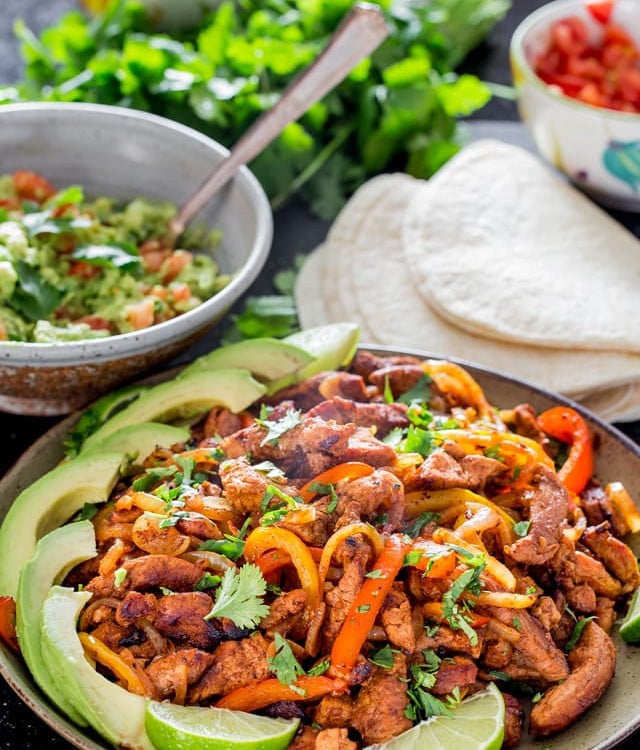 a plate full of the pork fajita filling garnished with sliced avocado