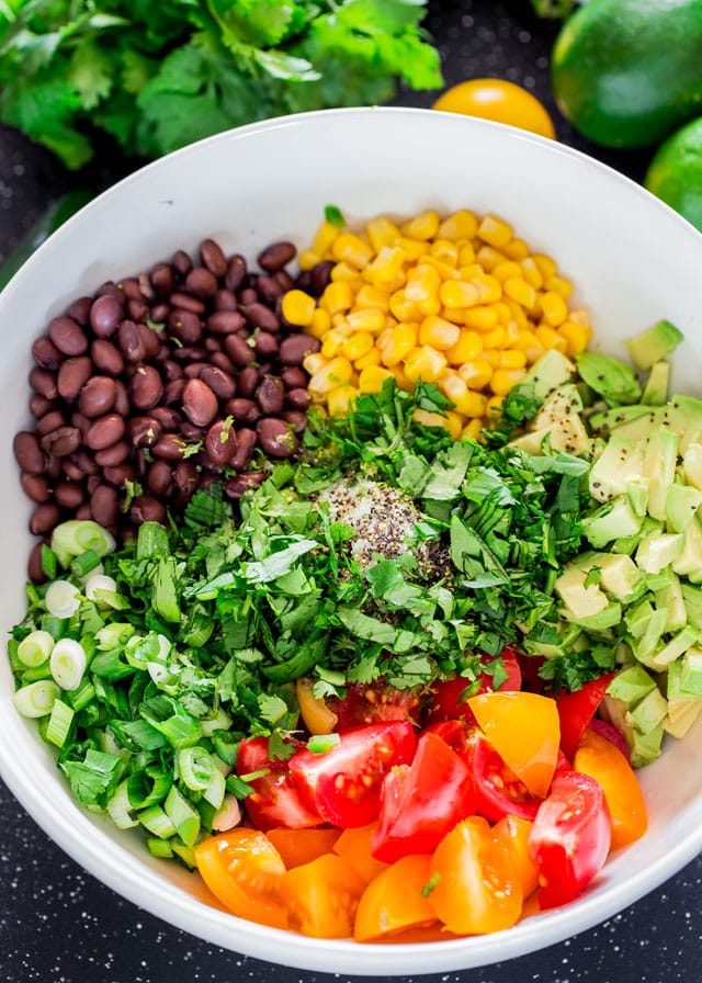 a bowl of black bean corn and avocado salad before mixing everything together