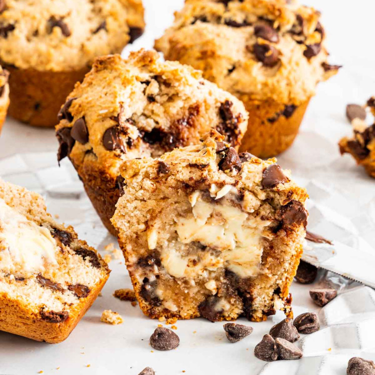 chocolate chip muffins, one cut in half with butter spread in the center