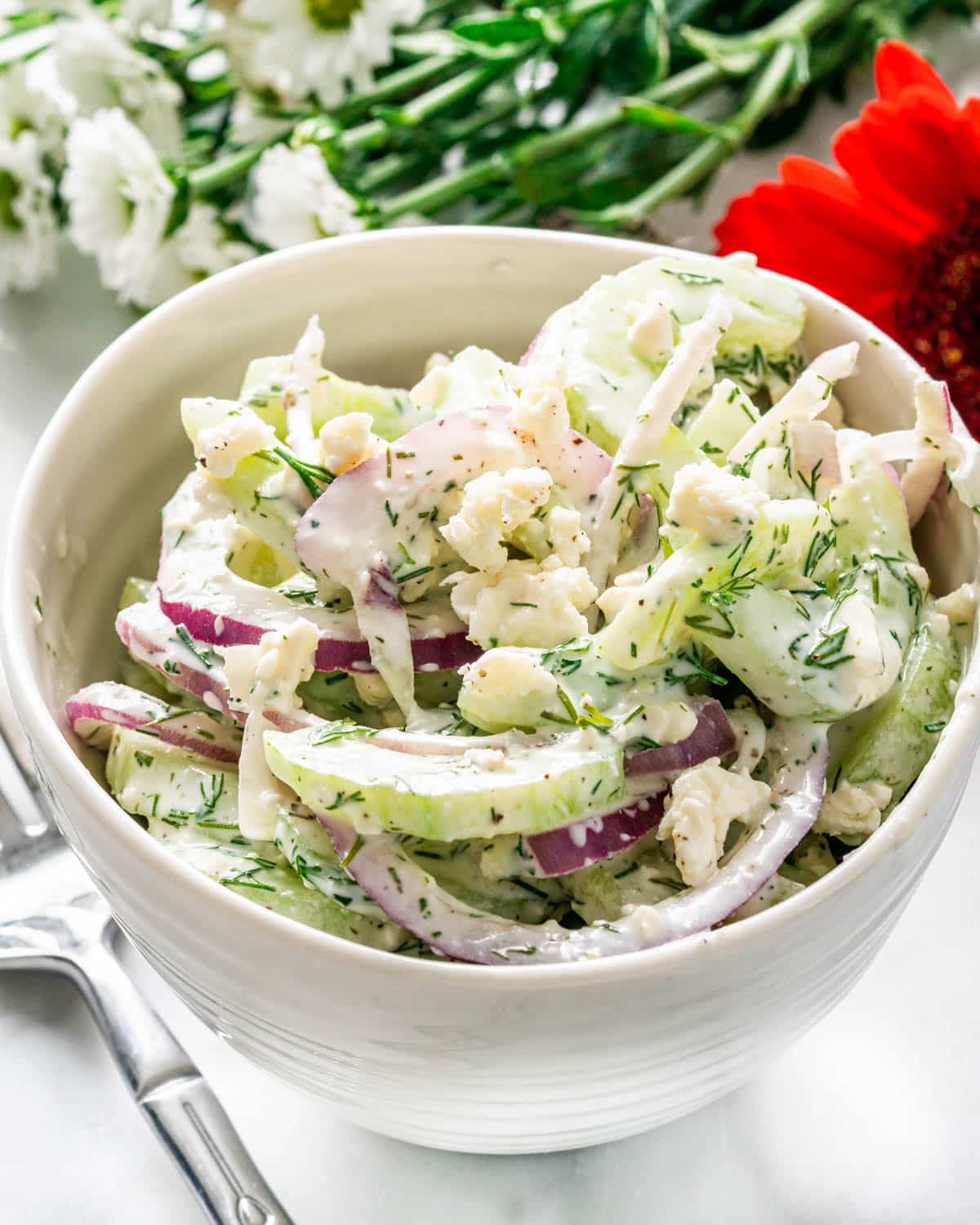 a serving of Creamy Cucumber Salad in a small white bowl