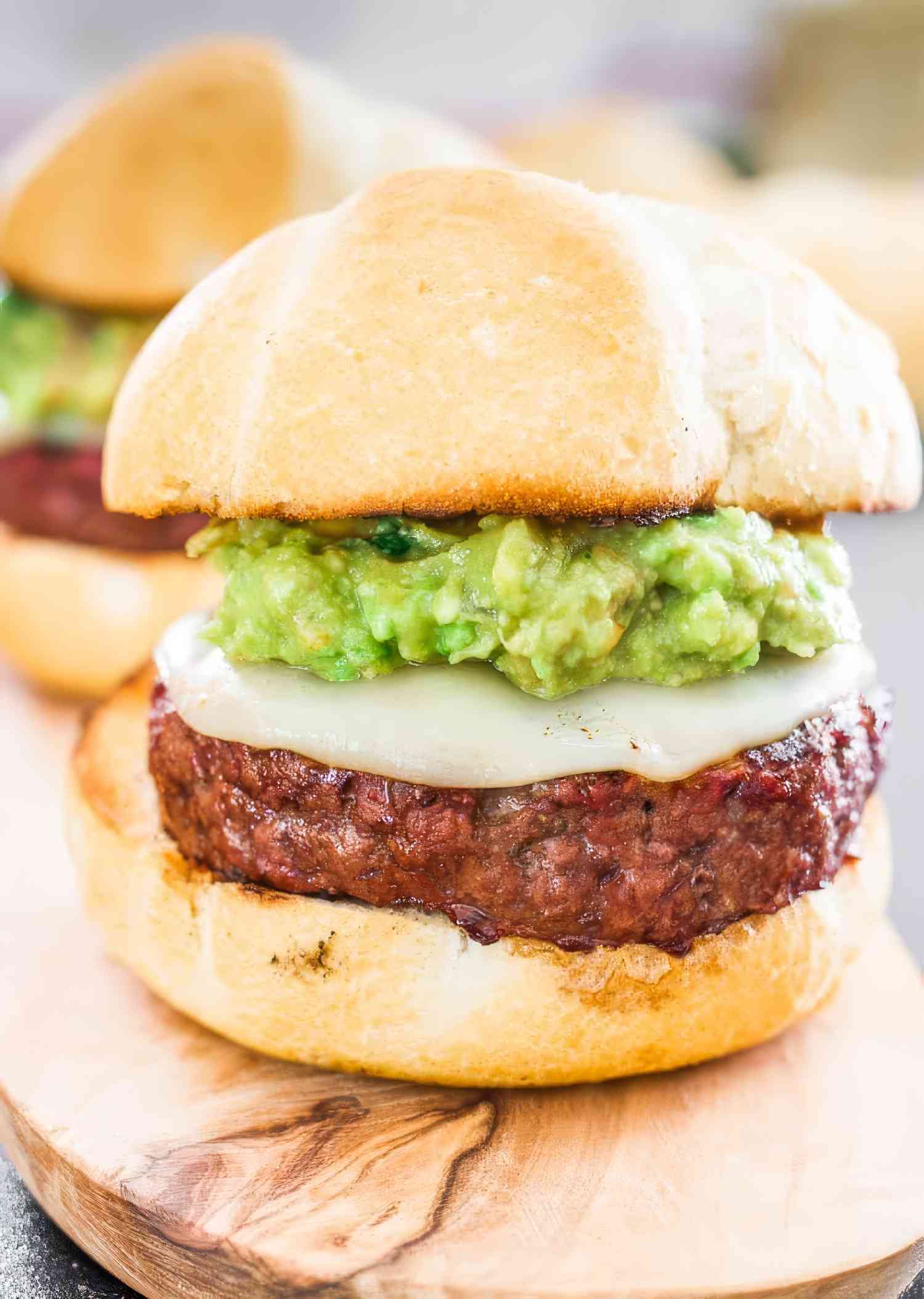 Close up of Burgers with Guacamole aka "The Beast" - a huge burger with guacamole and cheese on a toasted bun. 