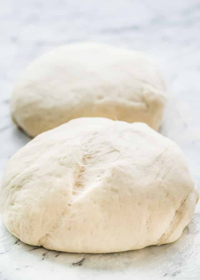 two balls of pizza dough on a cutting board