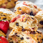 side view shot of a strawberry chocolate chip scone broken in half exposing the center