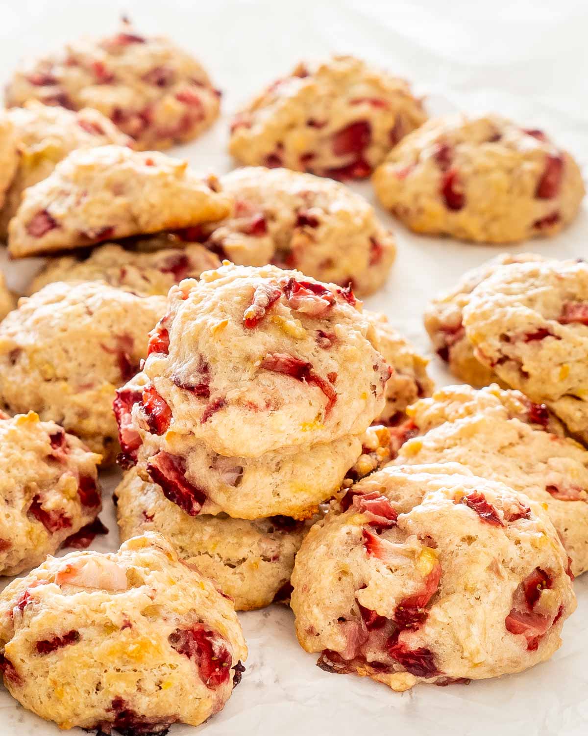 freshly baked strawberry cookies on parchment paper.