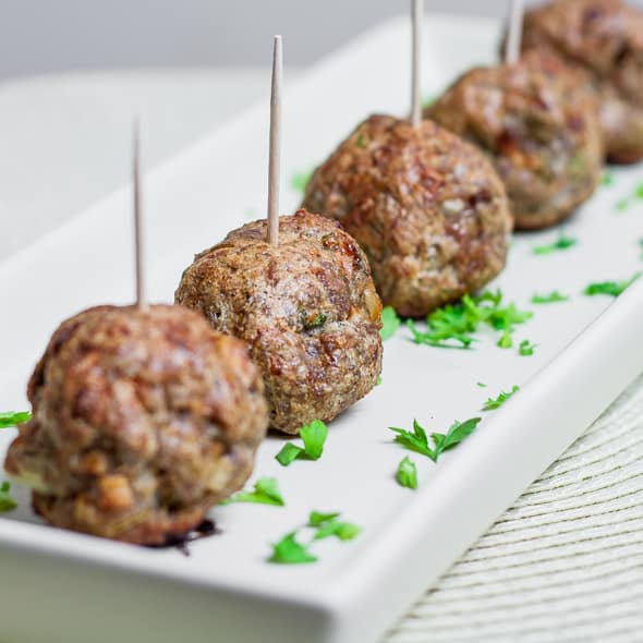 shot of baked lamb meatballs lined up with toothpicks in the top 