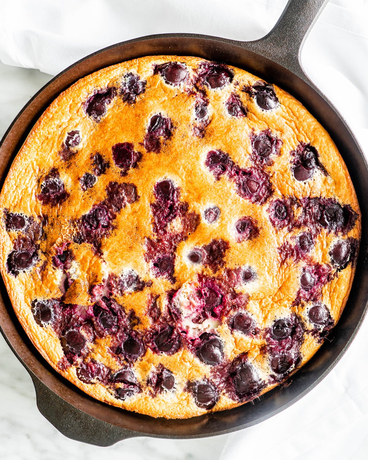 overhead shot of a cherry clafoutis in a skillet fresh out of the oven
