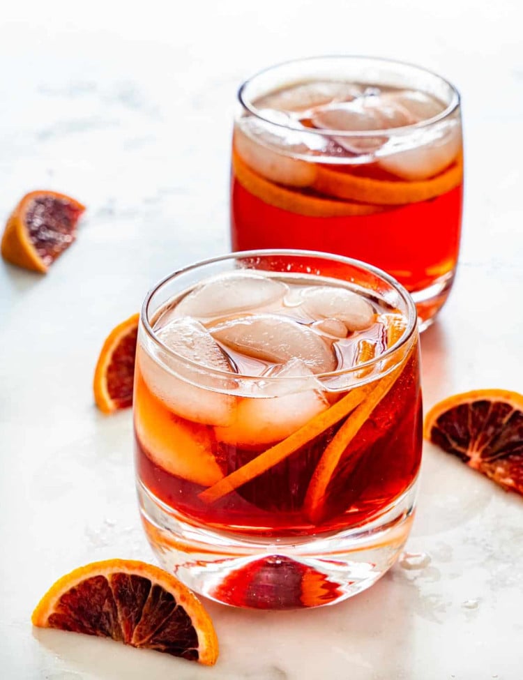 two americano cocktails in short classes, garnished with blood oranges