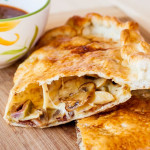 side view shot of bacon and mushroom calzone cut in half exposing the center