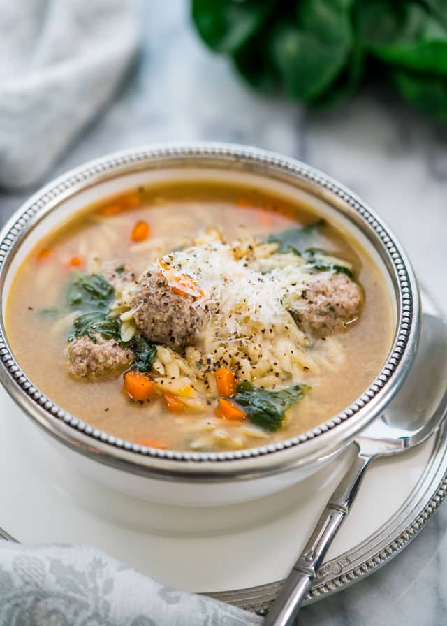 italian wedding soup in a bowl topped with parmesan cheese