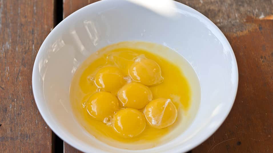 A bowl of egg yolks and oil.