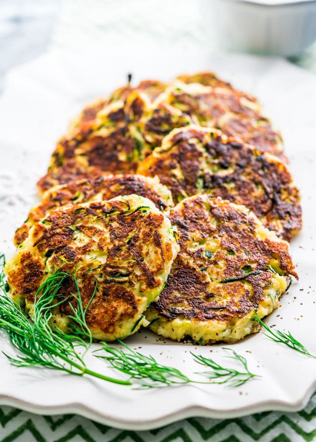 zucchini patties on a platter with fresh dill