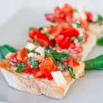 crostini topped with bruschetta with provolone cheese