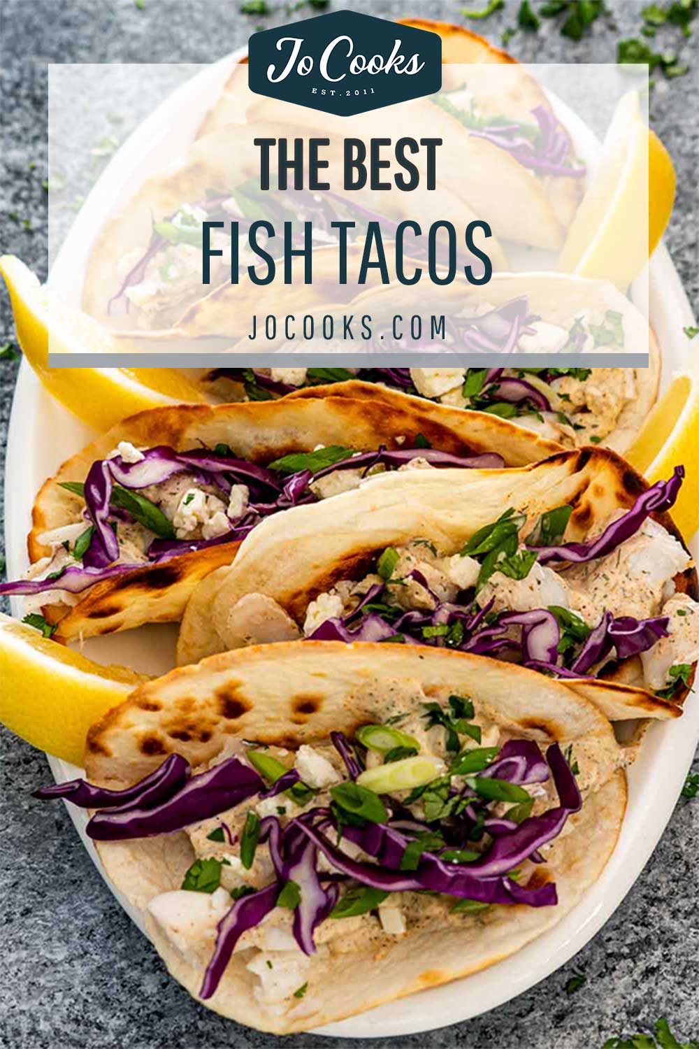 pin for freshly made fish tacos on a white serving platter.