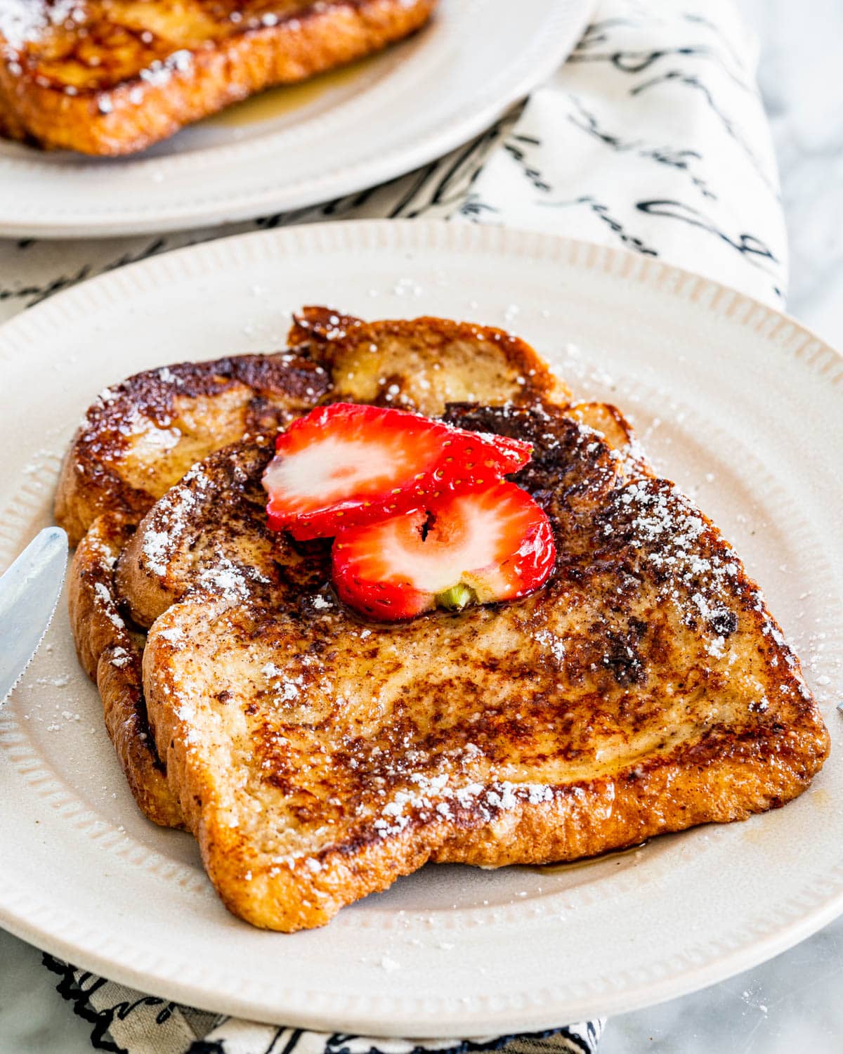 two slices of french toast topped with 2 slices of strawberries