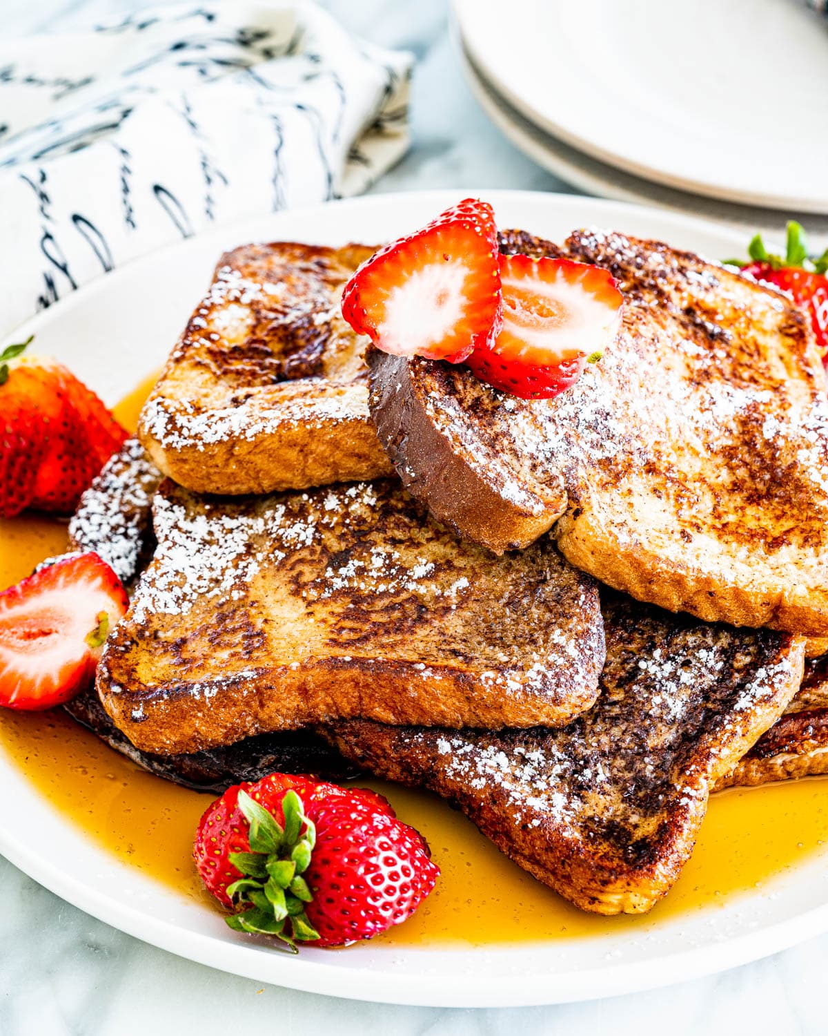 french toast drizzled with maple syrup and garnished with strawberries