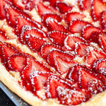 a beautiful strawberry tart on a blue plate.