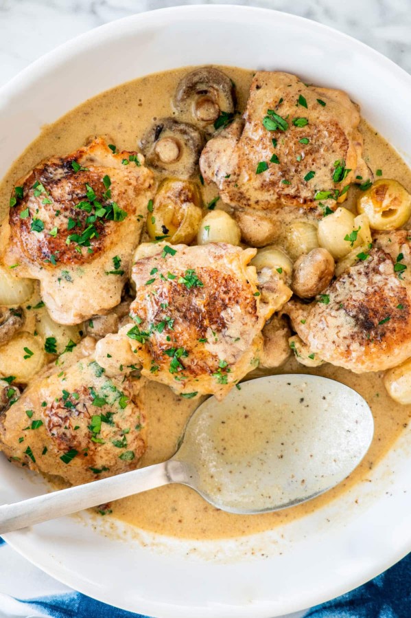 overhead shot of chicken fricassee with a serving spoon resting in the dish