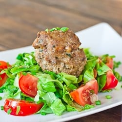 a plate of salad topped with a turkey meatball