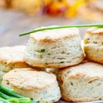a few chive and cream cheese biscuits on a plate garnished with fresh chives.