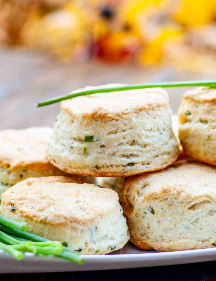 a few chive and cream cheese biscuits on a plate garnished with fresh chives.