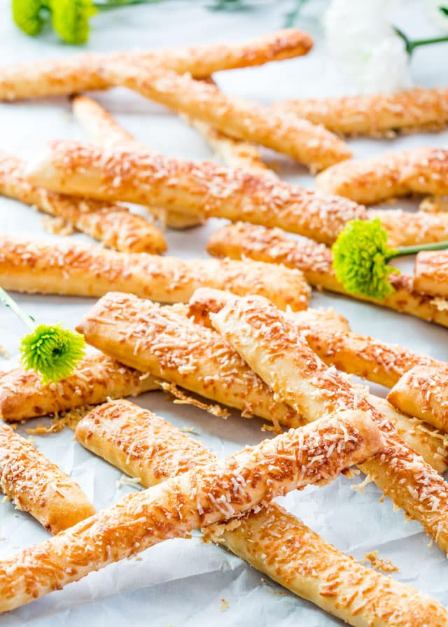 cheese sticks piled on parchment paper with chrysanthemums 