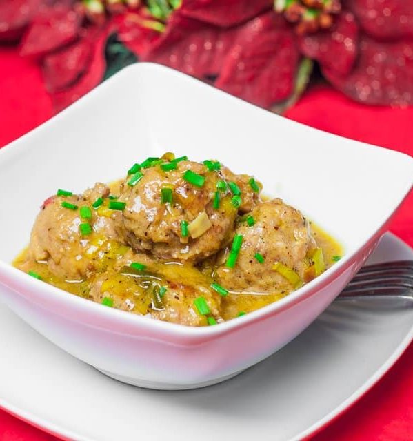 a bowl of meatballs with beer sauce and leeks