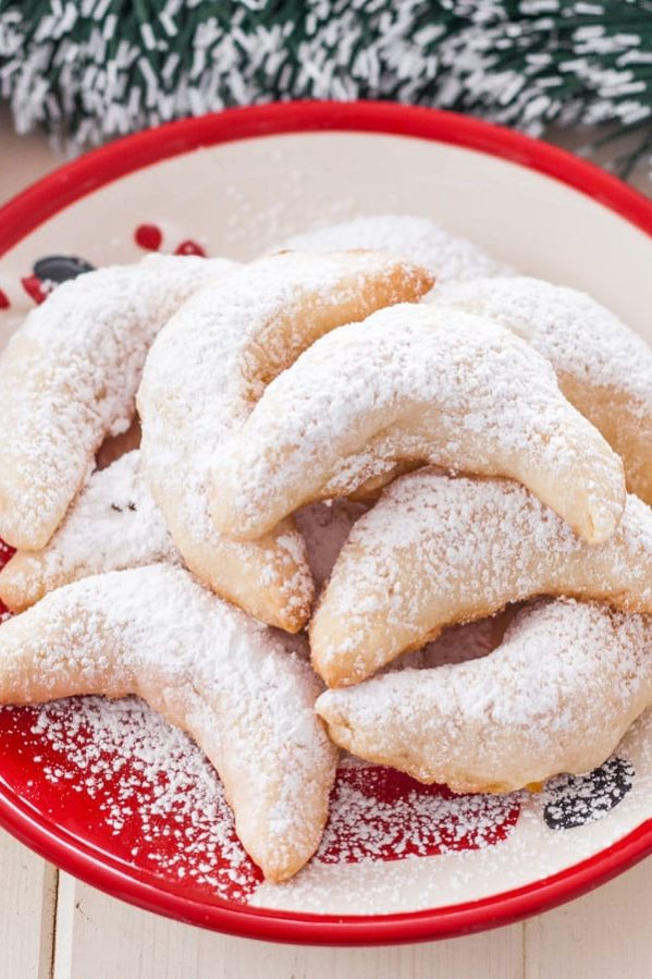 a plate of pineapple coconut crescents dusted with powdered sugar