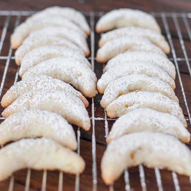 Pineapple Coconut Crescents on a cooling rack, dusted with powdered sugar
