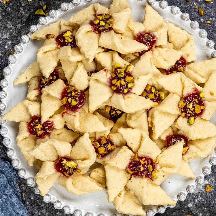 a plate full of raspberry pinwheels with pistachios.