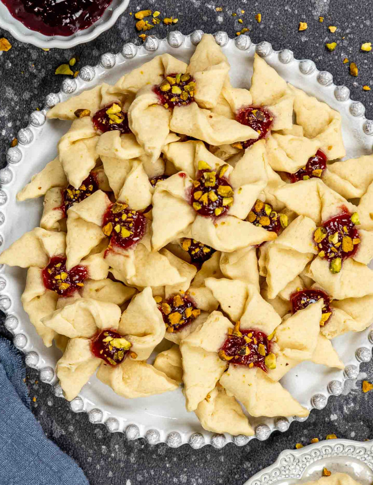 a plate full of raspberry pinwheels with pistachios.