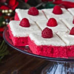 red velvet cake slices topped with fresh raspberries