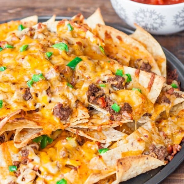 a plate of beef and cheese nachos with chorizo sausage