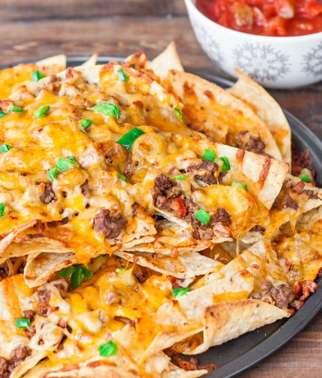 a plate of beef and cheese nachos with chorizo sausage