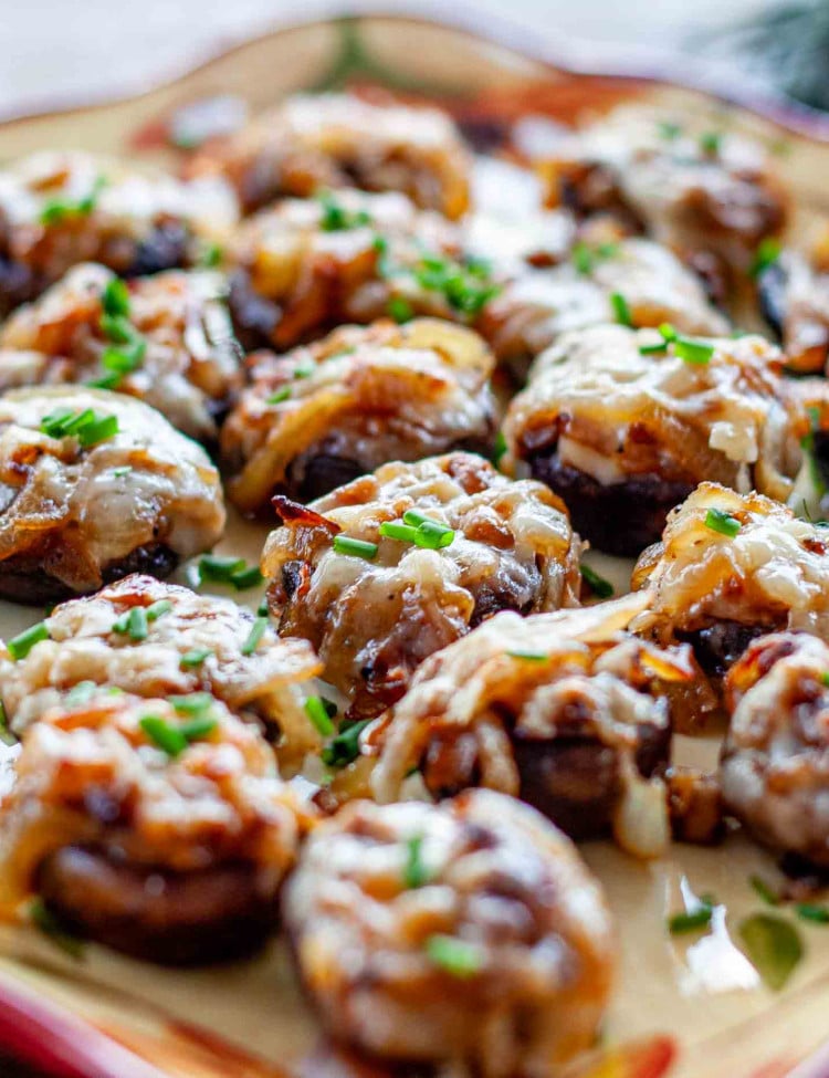 french onion stuffed mushrooms on a plate garnished with chives.