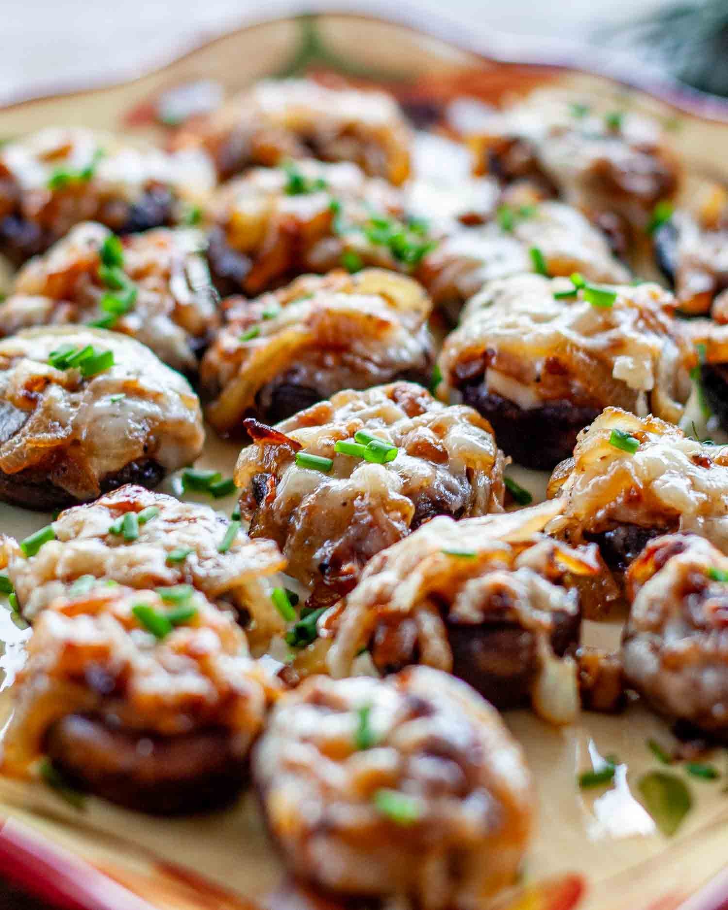 french onion stuffed mushrooms on a plate garnished with chives.