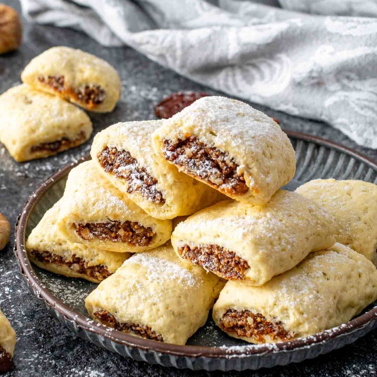 freshly baked italian fig cookies on a plate dusted with a bit of powdered sugar.