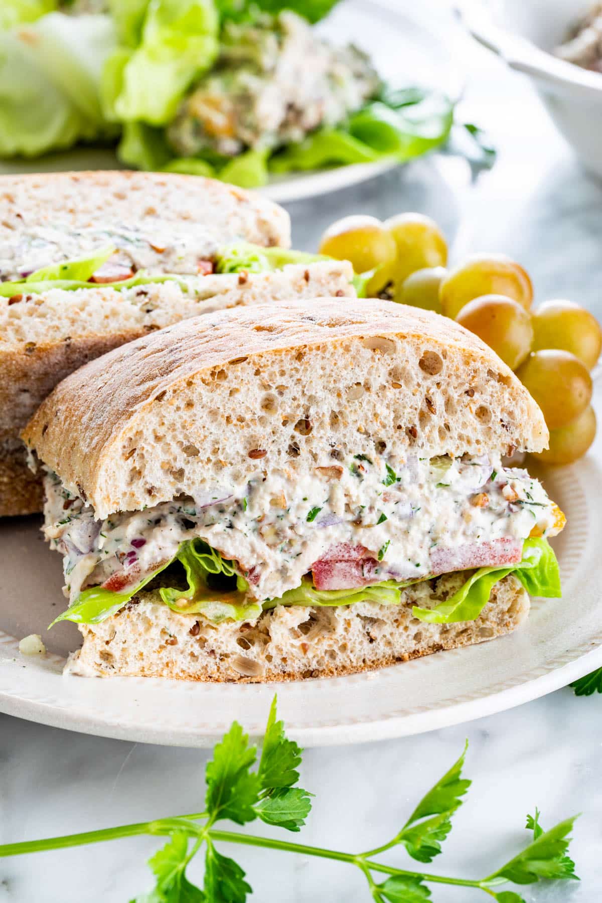 tuna salad sandwich cut in half on a white plate