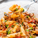 side view shot of a fork taking a bite of baked penne with italian sausage