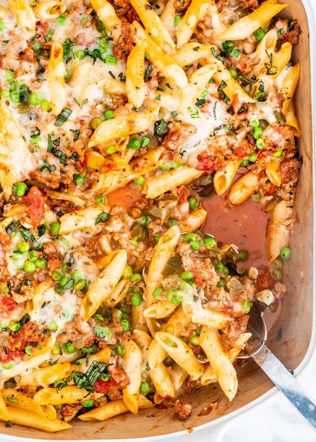 Baked Penne with Italian Sausage in a white casserole dish
