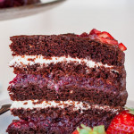 a slice of chocolate cake with mixed berry and cream cheese filling on a plate