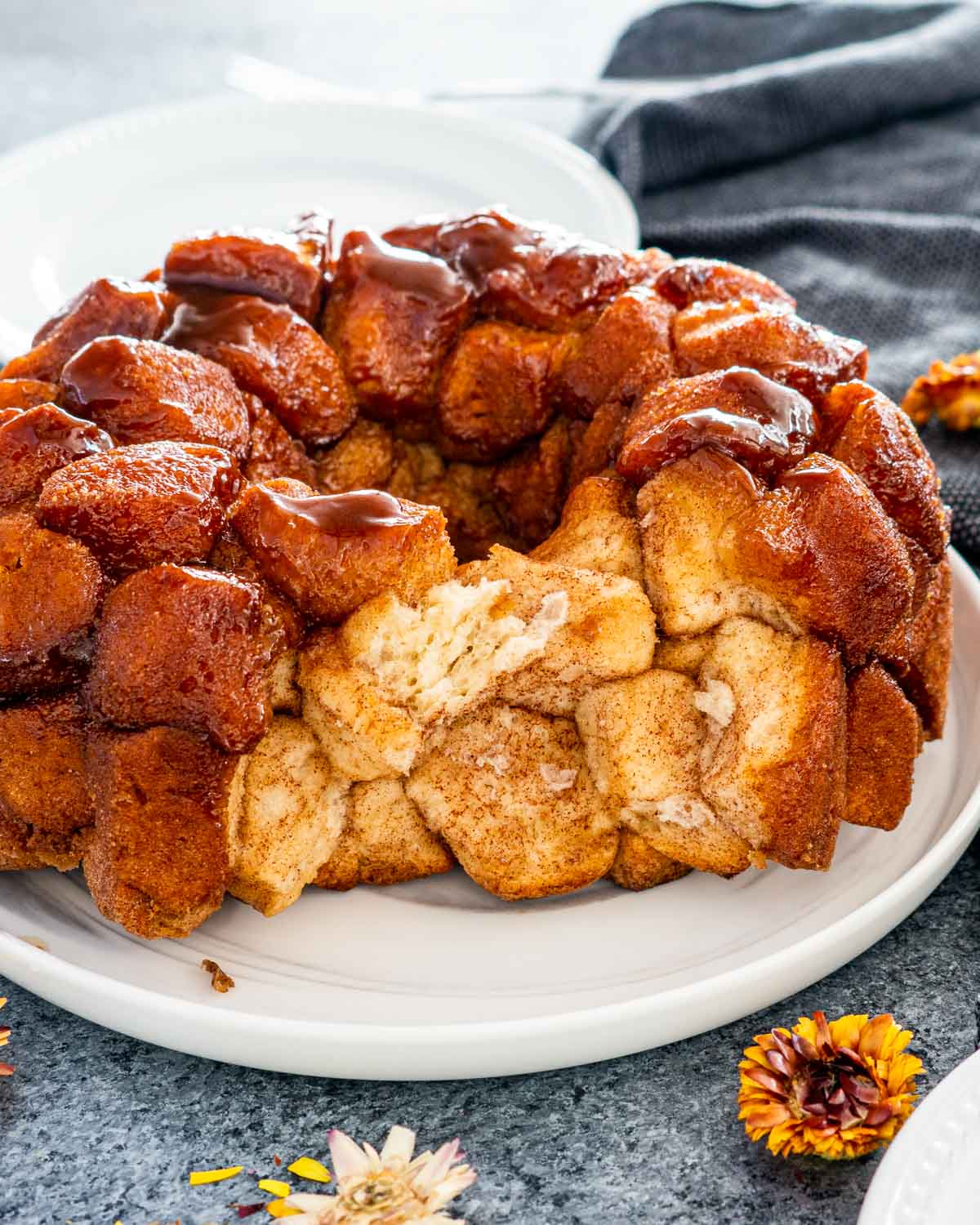 monkey bread with some pieces taken out on a white serving platter.