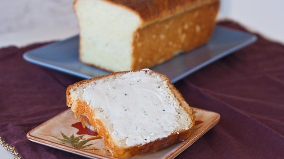 slices of brioche bread on a plate, one is covered in butter