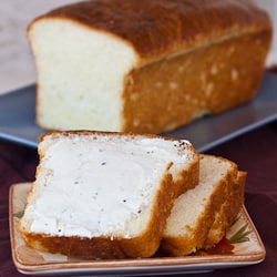slices of brioche bread on a plate, one is covered in butter