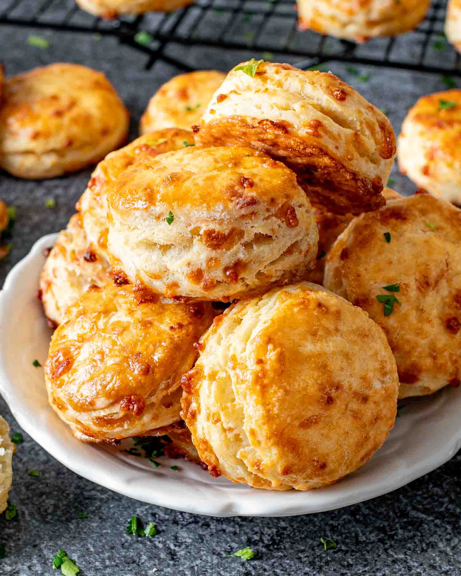a few freshly baked mozzarella biscuits on a white plate.