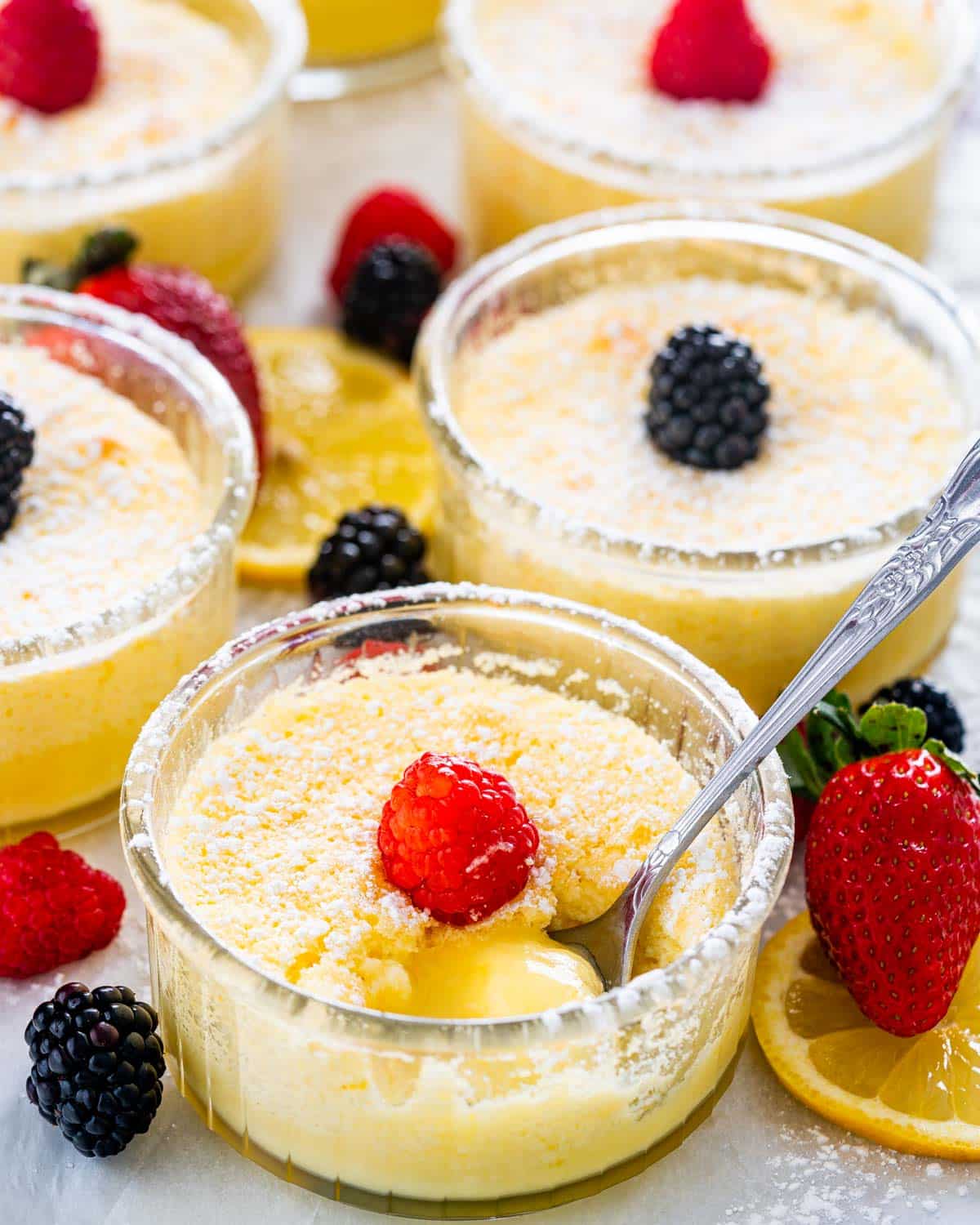 ramekins of lemon pudding cakes garnished with berries.