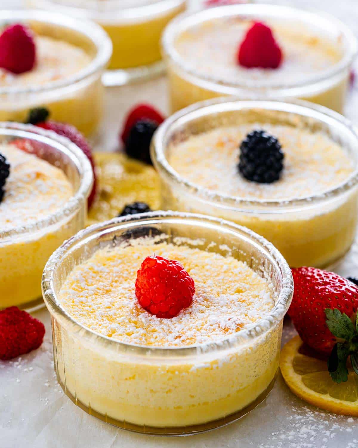 ramekins of lemon pudding cakes garnished with berries.